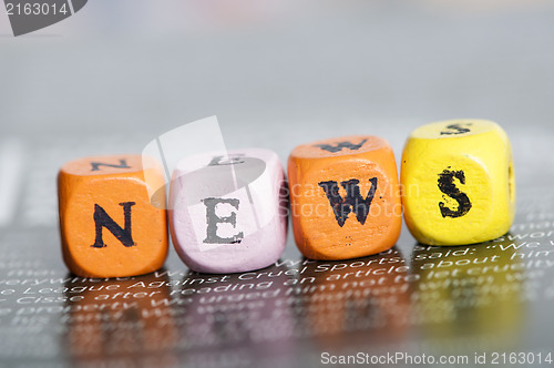 Image of Word news.Wooden cubes on magazine