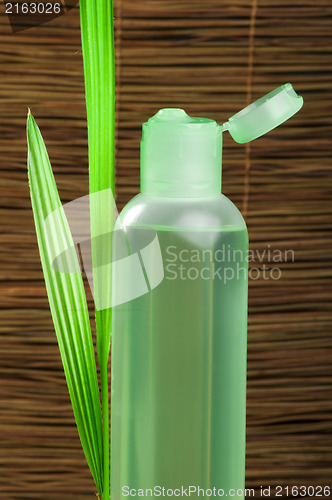 Image of Green cosmetic bottle and leaf