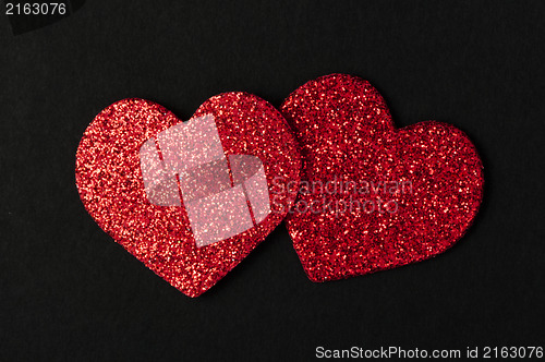 Image of Red shiny hearts on black background
