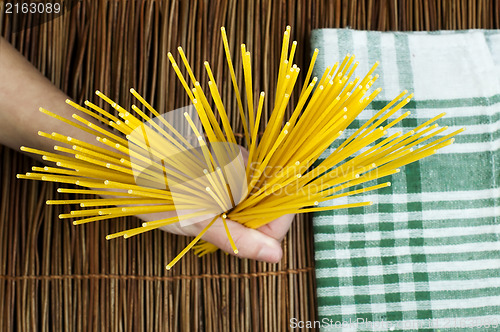 Image of Female hand holding spaghetti