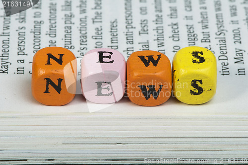 Image of Word news.Wooden cubes on magazine