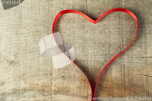 Image of Red ribbon heart on wooden background
