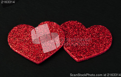 Image of Red shiny hearts on black background