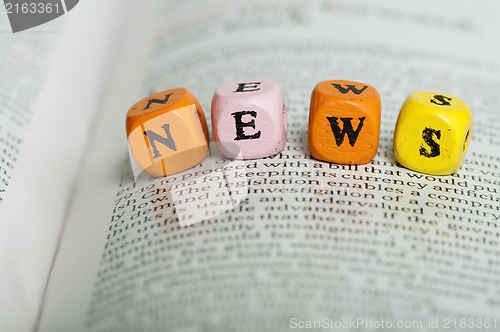 Image of Word news.Wooden cubes on magazine