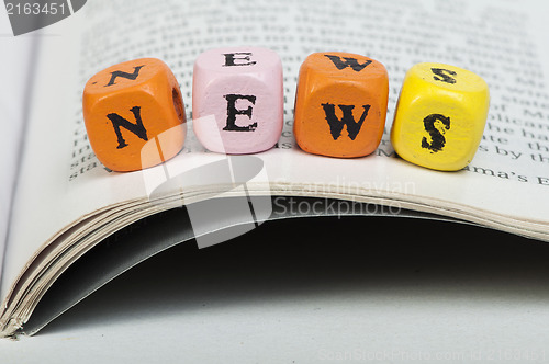 Image of Word news.Wooden cubes on magazine