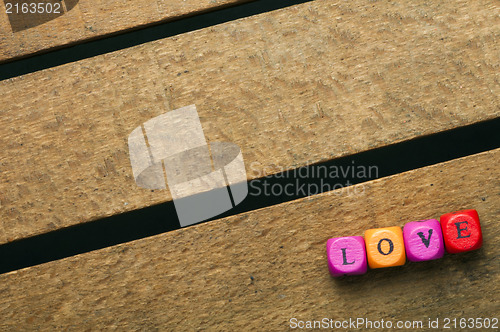 Image of Word love on multicolored wooden cubes on wood