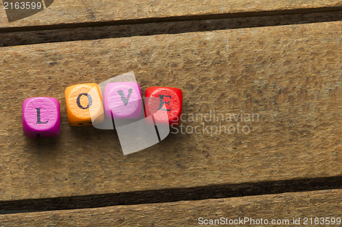 Image of Word love on multicolored wooden cubes on wood