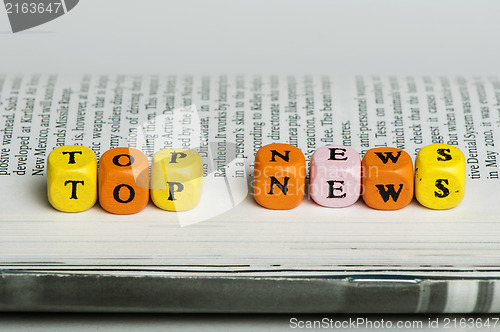 Image of Word top news.Wooden cubes on magazine