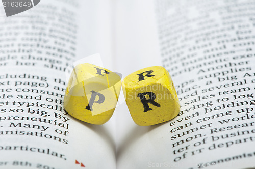 Image of Word PR.Wooden cubes on magazine