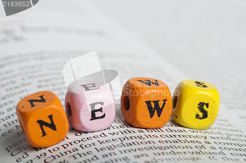 Image of Word news.Wooden cubes on magazine