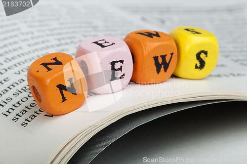 Image of Word news.Wooden cubes on magazine