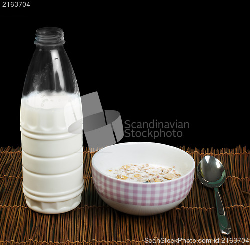 Image of Muesli breakfast in a bow, spoon and milk