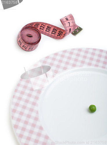 Image of Plate with one peas. Dumbbell and centimeter measure. 