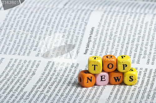 Image of Word top news.Wooden cubes on magazine