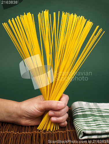 Image of Female hand holding spaghetti