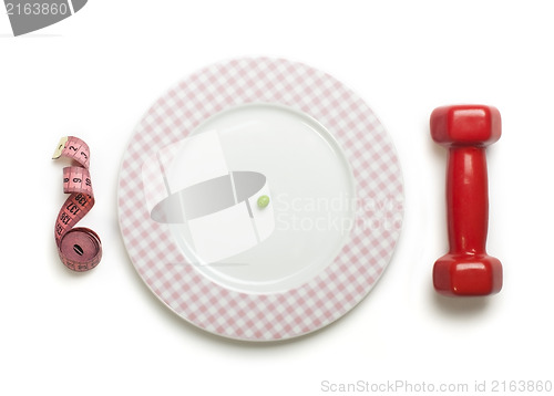 Image of Plate with one peas. Dumbbell and centimeter measure. 