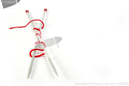 Image of Knitting skewers and red yarn