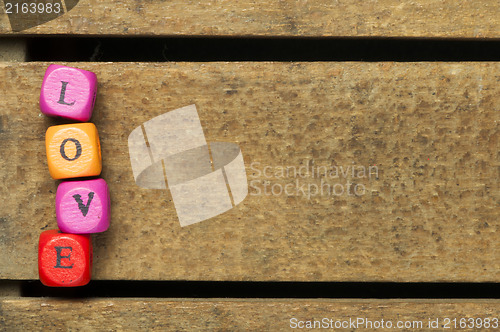 Image of Word love on multicolored wooden cubes on wood