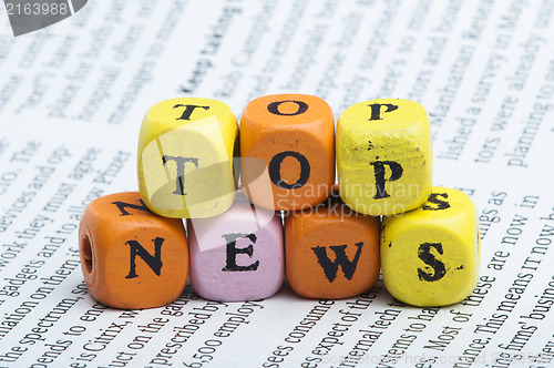 Image of Word top news.Wooden cubes on magazine