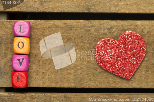 Image of Word love on multicolored wooden cubes on wooden background