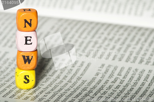 Image of Word news.Wooden cubes on magazine