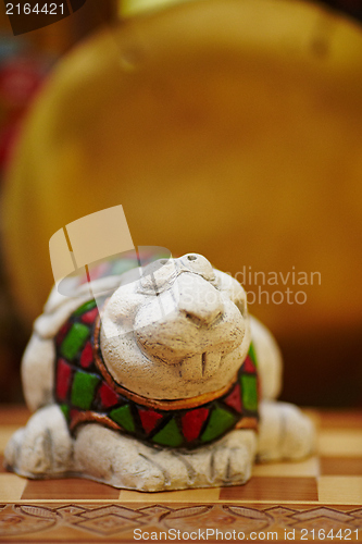 Image of Figurine of chameleon on a chess-board.