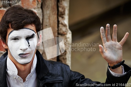 Image of Guy mime against an old brick wall.