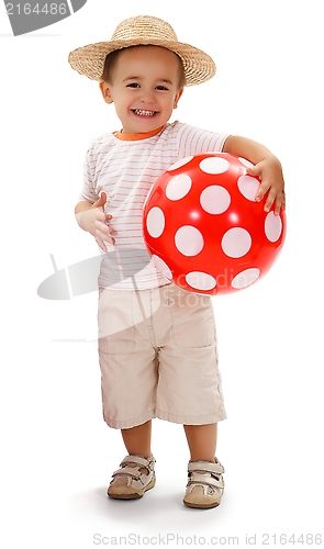 Image of Cheerful little boy in straw hat, holding red dotted ball