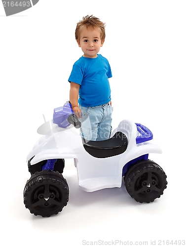 Image of Little boy standing near toy off road quad