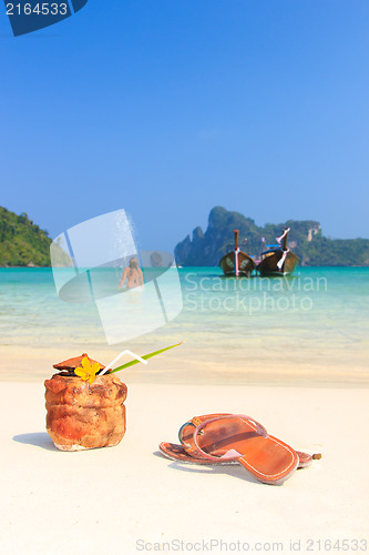 Image of Coconut cocktail and young female model on the beach