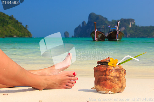 Image of Coconut cocktail and woman's legs