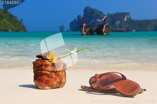 Image of Coconut cocktail and sandals on the beach