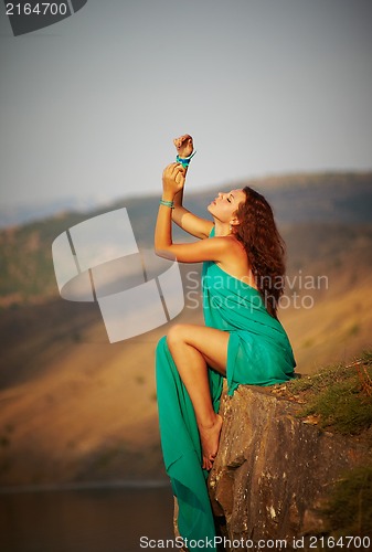 Image of Girl sitting on the edge of a cliff.