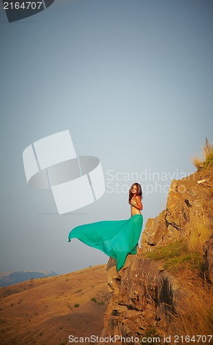 Image of Beautiful girl standing on a precipice.