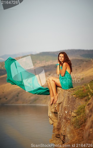 Image of Girl sitting on the edge of a cliff