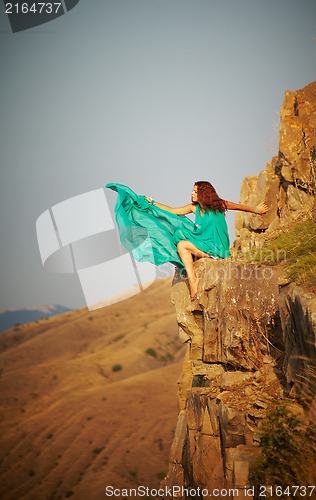 Image of Girl sitting on the precipice of a cliff.