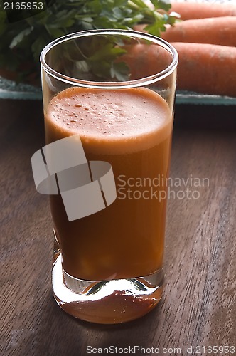 Image of carrot juice on a wooden background 