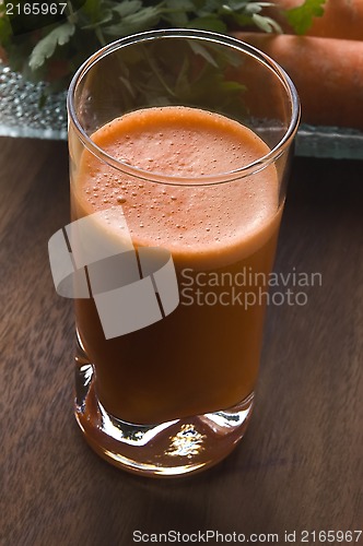 Image of carrot juice on a wooden background 