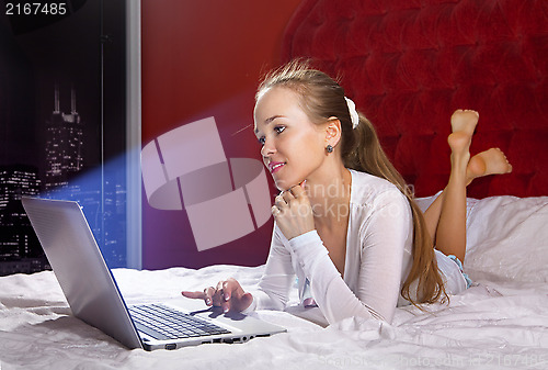 Image of young woman on bed with laptop