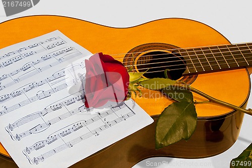Image of A guitar and a rose.