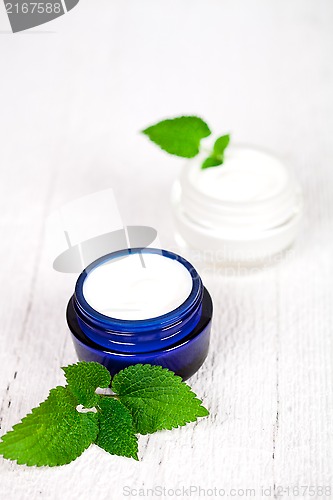 Image of face cream in jars with urtica leaves