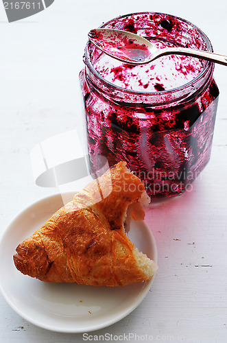 Image of croissant and  pot of jam 