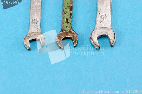 Image of three screw spanners wrench tools blue background 