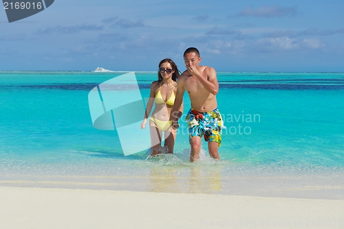 Image of happy young  couple enjoying summer on beach