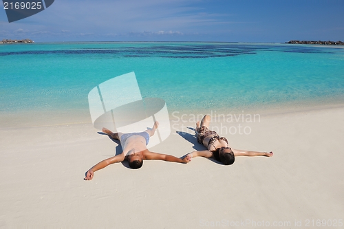 Image of happy young  couple enjoying summer on beach
