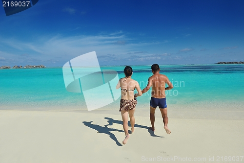 Image of happy young  couple enjoying summer on beach