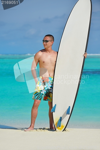 Image of Man with surf board on beach