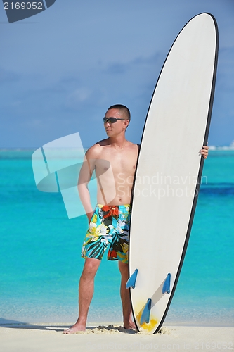 Image of Man with surf board on beach