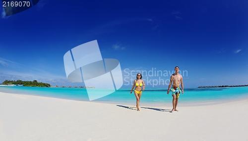 Image of happy young  couple enjoying summer on beach