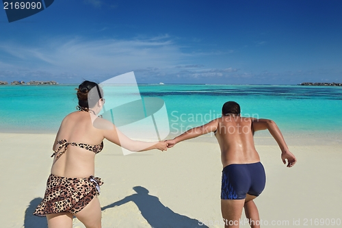 Image of happy young  couple enjoying summer on beach